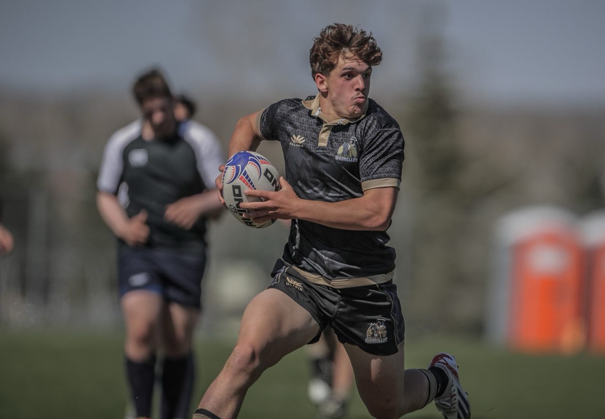 High school rugby player carrying the ball upfield