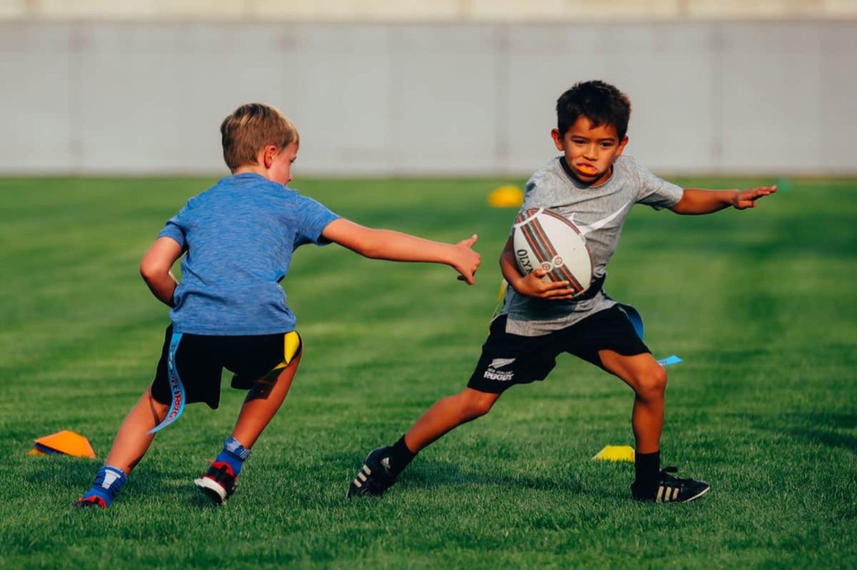 Young players in rugby cleats chasing the ball