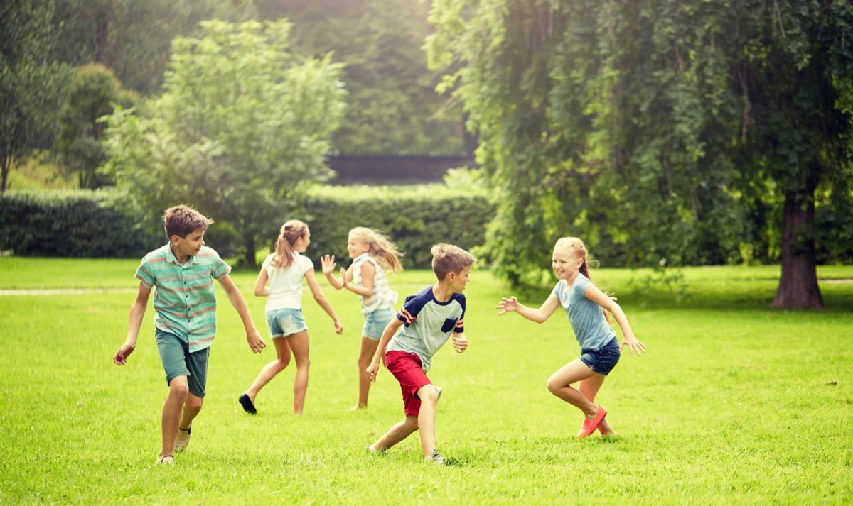 Kids playing a running game on a summer field