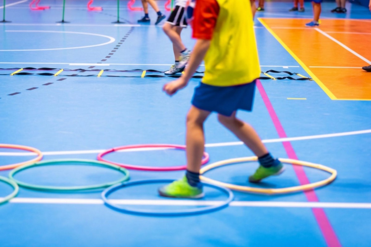 Student hopping through agility rings in a school gym