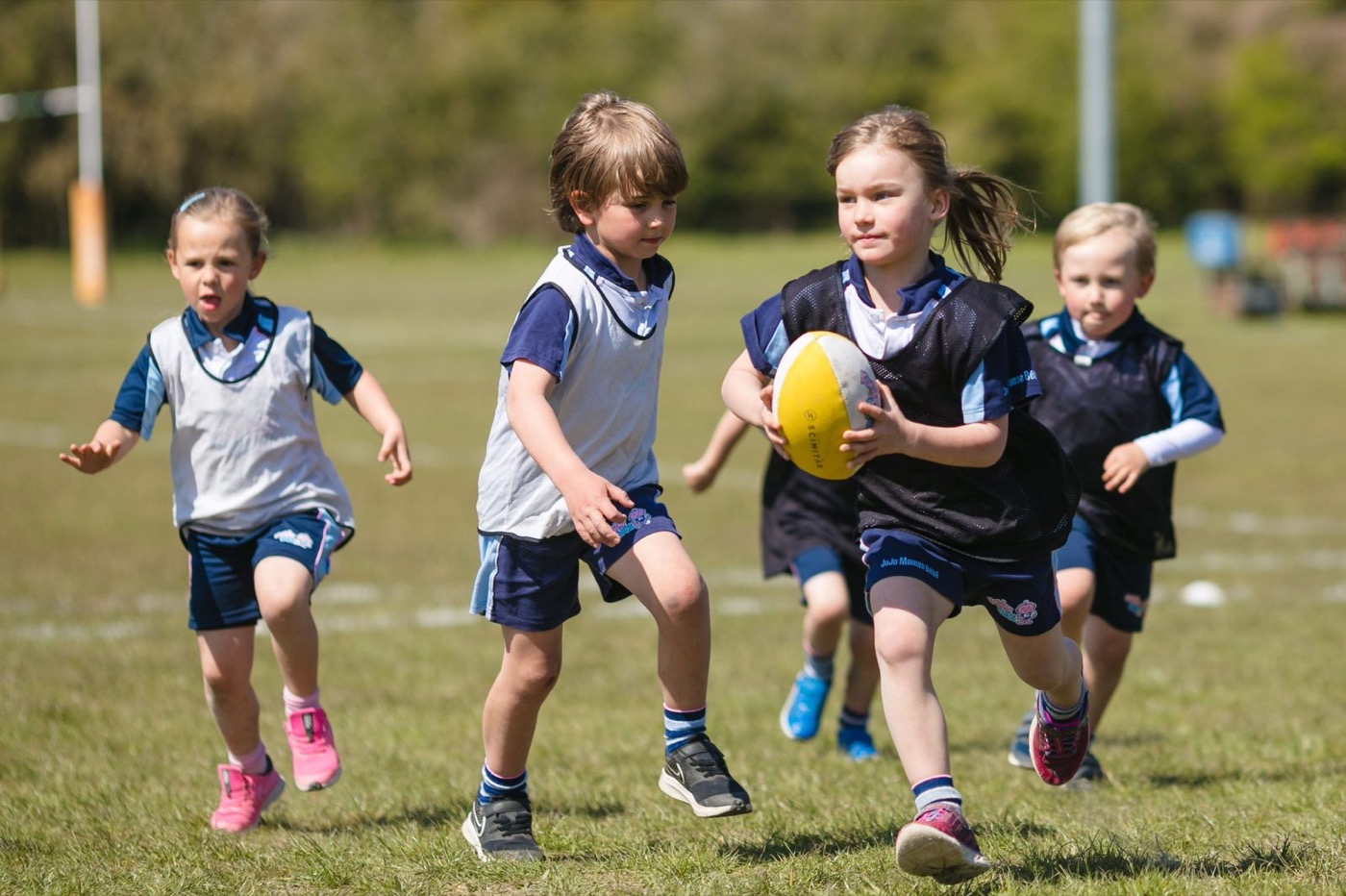 Young kids running with a rugby ball during a TRY Rugby session